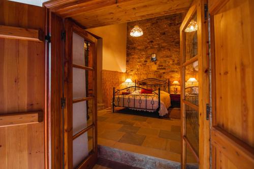a bedroom with a bed in a stone wall at Constantias stone houses in Lofou