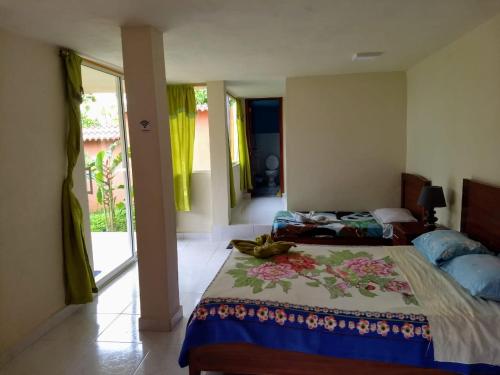 Un dormitorio con una cama con una manta de colores. en Hostal Tena Ñaui, en Tena