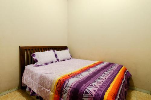 a bedroom with a bed with a colorful blanket and pillows at Nurudin House in Borobudur