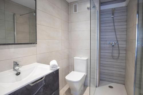 a bathroom with a toilet and a sink and a shower at Apartamentos BCL Playa Albir in Albir