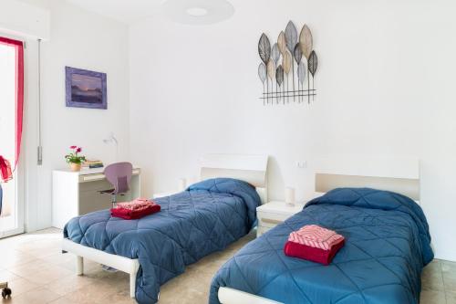 1 dormitorio con 2 camas azules y escritorio en Parma Railway Station Lovely Apartment, en Parma