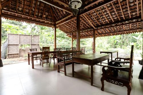 un comedor con mesas y sillas en un pabellón en Nurudin House en Borobudur