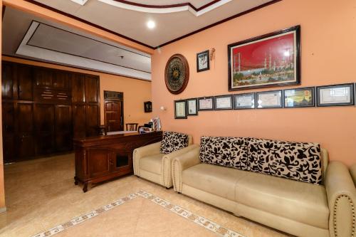 a living room with a couch and a desk at Nurudin House in Borobudur