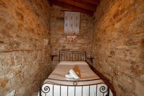 a small room with a bed in a stone wall at Constantias stone houses in Lofou
