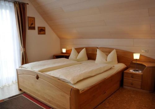 Un dormitorio con una gran cama de madera con almohadas blancas. en Gasthaus Tauberstube, en Rothenburg ob der Tauber