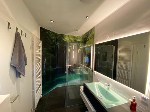 a bathroom with a green sink and a tub at Schwalm-Apartment Treysa in Schwalmstadt
