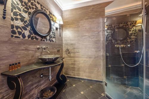 uma casa de banho com um lavatório e um chuveiro em Pałacyk Deja Vu Residence em Lódź