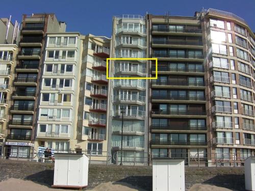 a tall apartment building with a yellow rectangle on it at Beau Séjour in Westende-Bad