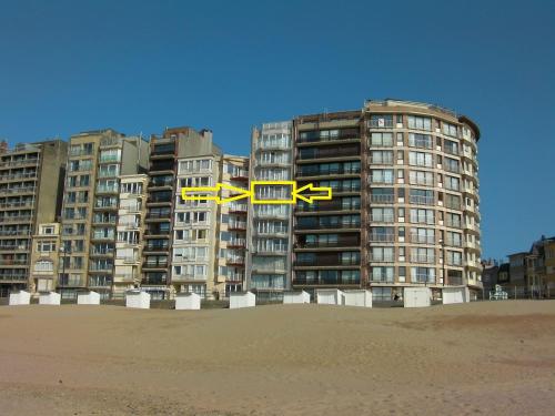 two buildings on the beach in front of the sand at Beau Séjour in Westende-Bad