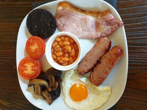 ブリッジノースにあるStoneway Guest Houseの卵ソーセージ豆とトマトを添えた朝食用の皿