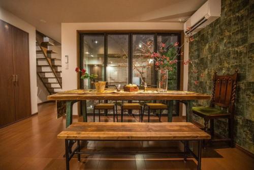 a dining room with a large wooden table and chairs at 喜楽・翡翠 in Kyoto