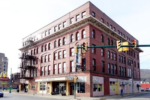 a large red brick building on a street corner at OYO Hotel Bradford Main St PA in Bradford