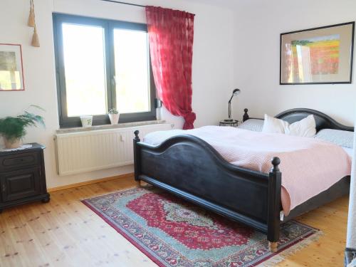 een slaapkamer met een groot bed en een tapijt bij Ferienwohnung am Walde in Rauda