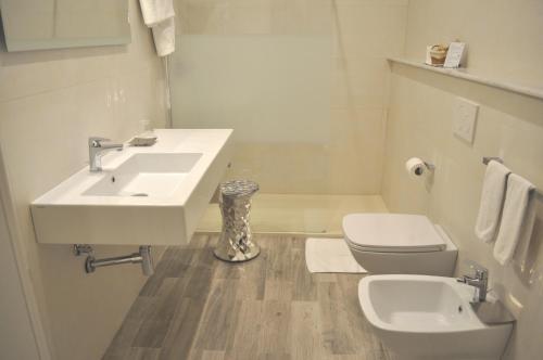 a white bathroom with a sink and a toilet at Hotel Boncardo in Finale Ligure