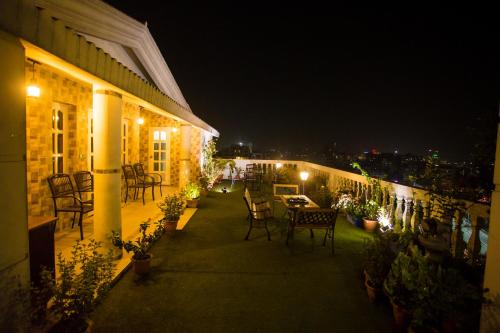 a patio at night with chairs and a table at Shinepukur Suites in Dhaka