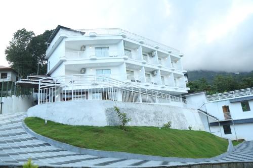 a white building with stairs in front of it at Moonline Resort in Anaviratty