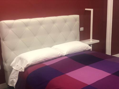 a white bed with a purple and purple carpet at SUNSET BED AND BREAKFAST in Naples