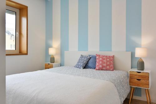 フィゲイラ・ダ・フォズにあるMaestro Apartment by Trip2Portugalのベッドルーム(白いベッド1台、ランプ2つ付)