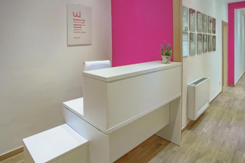un escritorio blanco en una habitación con una pared rosa en Seaview Rooms in the center by Wonderful Italy, en Cefalú