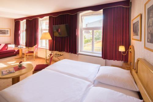 a hotel room with a bed and a living room at Hotel Kastanienhof in Berlin