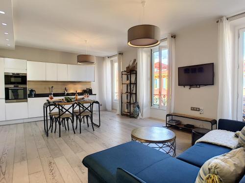 un salon avec un canapé bleu et une cuisine dans l'établissement Nestor&Jeeves - MASSENA DREAM - Hyper center - Close sea, à Nice