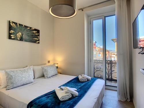 une chambre avec un lit et une grande fenêtre dans l'établissement Nestor&Jeeves - MASSENA DREAM - Hyper center - Close sea, à Nice