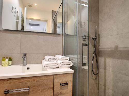 La salle de bains est pourvue d'un lavabo, d'une douche et de serviettes. dans l'établissement Nestor&Jeeves - MASSENA DREAM - Hyper center - Close sea, à Nice