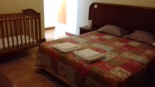 ein Schlafzimmer mit einem Bett mit zwei Handtüchern darauf in der Unterkunft Apartamento Arrifes in Porto Santo