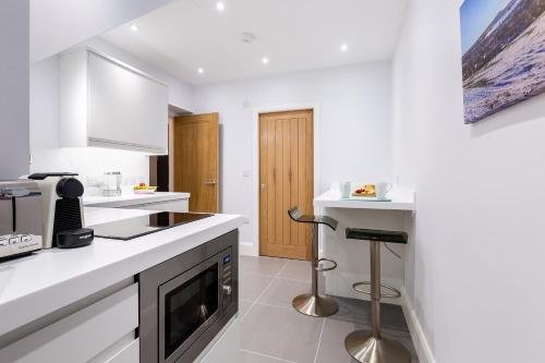 Rothbury Hideaway في روثبيري: مطبخ أبيض مع حوض وموقد