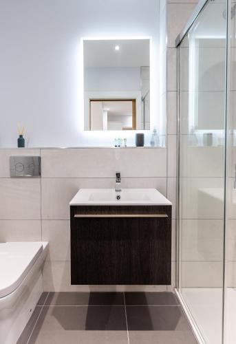 a white bathroom with a sink and a shower at Rothbury Hideaway in Rothbury