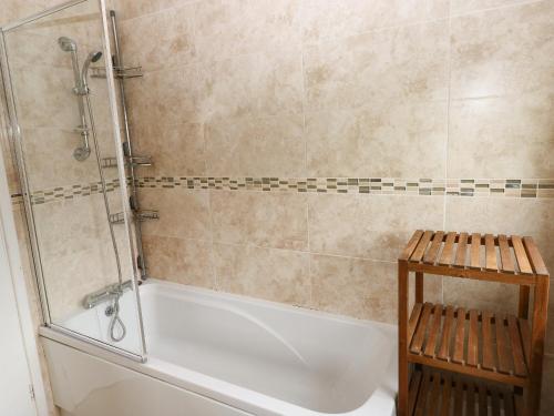 a bathroom with a tub and a shower at The Old Bakehouse in Llantwit Major
