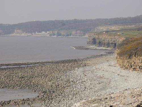 a rocky beach next to a body of water at The Old Bakehouse in Llantwit Major