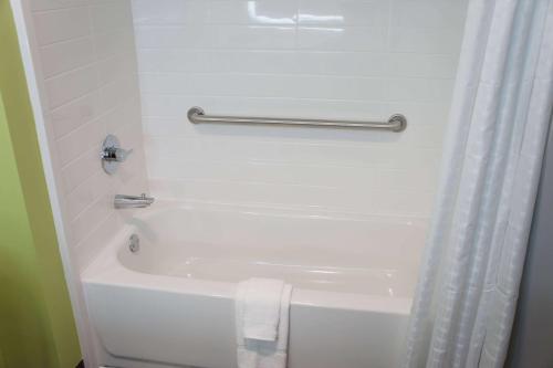 a white bathroom with a tub and a towel at La Quinta Inn & Suites by Wyndham Braselton in Braselton