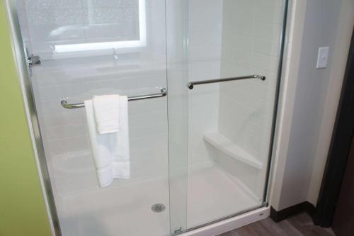 a shower with a glass door with a towel at La Quinta Inn & Suites by Wyndham Braselton in Braselton