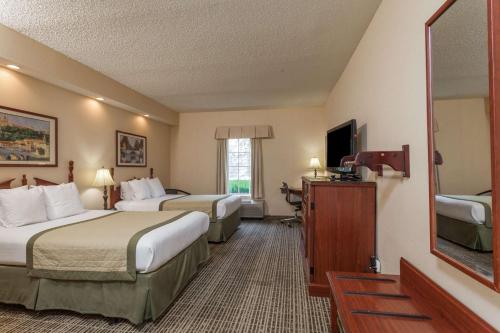 a hotel room with two beds and a television at Baymont by Wyndham Columbia Maury in Columbia