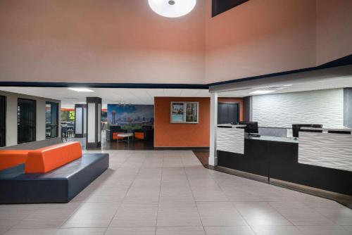 an office lobby with an orange couch in the middle at La Quinta by Wyndham Knoxville East in Knoxville