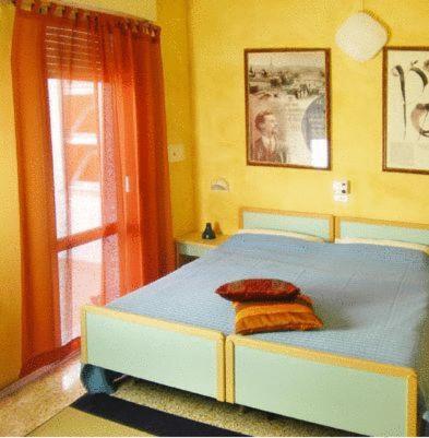 a bedroom with a blue bed and a window at Hotel Vallechiara in Cesenatico