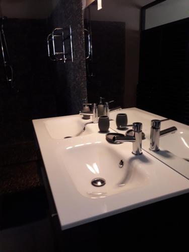 een witte wastafel in een badkamer met een spiegel bij residence LE SUD in Sainte-Anne