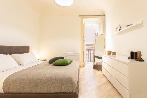 Dormitorio blanco con cama con almohada verde en Appartamento al Consiglio Reginale by Wonderful Italy, en Siracusa