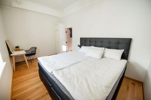 Lossi 32 Lux Apartment في تارتو: غرفة نوم بسرير كبير مع شراشف بيضاء