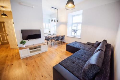 a living room with a couch and a flat screen tv at Lossi 32 Lux Apartment in Tartu