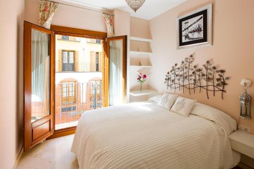 ein Schlafzimmer mit einem großen Bett und einem großen Fenster in der Unterkunft Veoapartment Santa Cruz in Sevilla