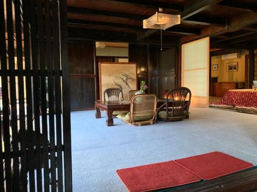 a room with chairs and a table and a painting at Yakuno House in Fukuchiyama