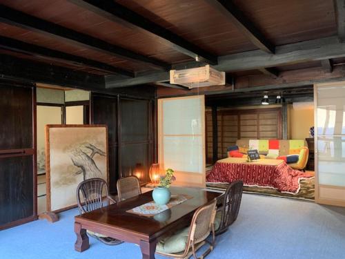 una camera con letto, tavolo e sedie di Yakuno House a Fukuchiyama