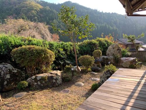 a garden with rocks and a wooden walkway at Yakuno House in Fukuchiyama