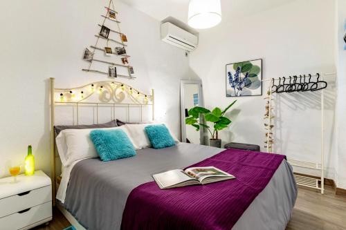 a bedroom with a bed with a book on it at My Granada Garden - Apartamento Orquídea in Granada