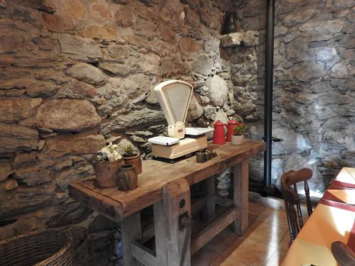 d'un mur en pierre avec une table et un sèche-cheveux. dans l'établissement Le Pic de Pan - Auberge & Gîtes, à Arrens-Marsous