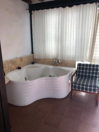 
a bath tub sitting in a bathroom next to a window at Ambelikos Traditional Agrohotel in Potamitissa
