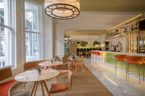 un restaurante con mesas y sillas y un bar en Meliá London Kensington Member of Meliá Collection, en Londres
