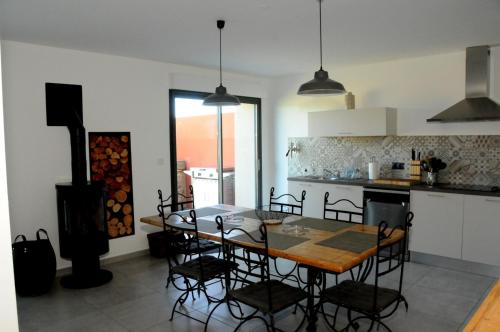 a kitchen with a table and chairs in a room at MAS CAMBEL in Brouilla